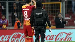 Pemain Galatasaray, Yasin Oztekin melakukan selebrasi bersama petugas polisi setelah mencetak gol saat melawan Gaziantepspor dalam Liga Super Turki di Istanbul, Minggu (11/12). (AFP PHOTO/STR)