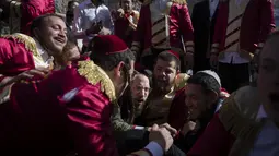 Yahudi Ultra-Ortodoks merayakan setelah minum alkohol selama hari libur Yahudi Purim di ultra-Ortodoks Mea Shearim, Yerusalem (28/2/2021). Hari libur Purim Yahudi memperingati keselamatan orang Yahudi dari genosida di Persia kuno, seperti yang diceritakan dalam Kitab Ester. (AP Photo/Oded Balilty)