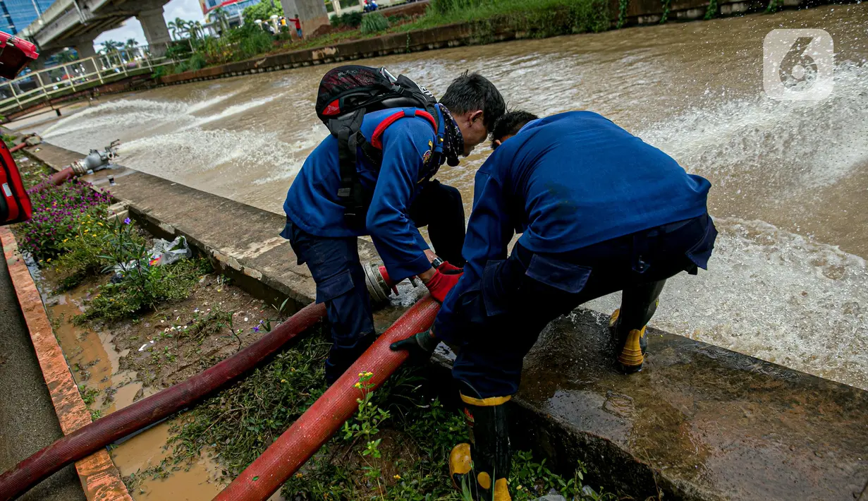 Petugas pemadan kebakaran menyedot air banjir di kawasan Cipinang Melayu, Jakarta, Minggu (21/2/2021). Suku Dinas Pemadam Kebakaran Jakarta Timur mengerahkan 20 mobil pompa untuk menyedot air yang membanjiri RW 04 Kelurahan Cipinang Melayu untuk mengurangi debit air. (Liputan6.com/Faizal Fanani)