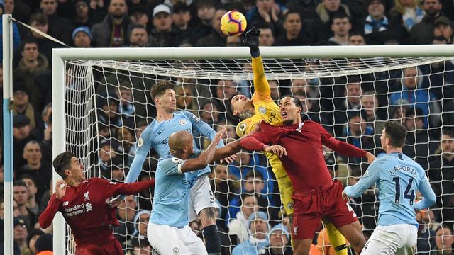 Kiper Manchester City, Ederson, menepis bola saat melawan Liverpool pada laga Premier League di Stadion Etihad, Manchester, Kamis (4/1). City menang 2-1 atas Liverpool. (AFP/Oli Scarff)