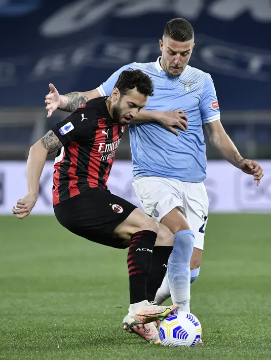 Bek AC Milan, Theo Hernandez (kiri) bersaing dengan gelandang Lazio, Sergej Milinkovic-Savic dalam laga pekan ke-33 Liga Italia 2020-2021 di Stadio Olimpico, Selasa dinihari WIB (27/4/2021). AC Milan kalah telak 3-0 saat menyambangi kandang Lazio. (Filippo MONTEFORTE / AFP)