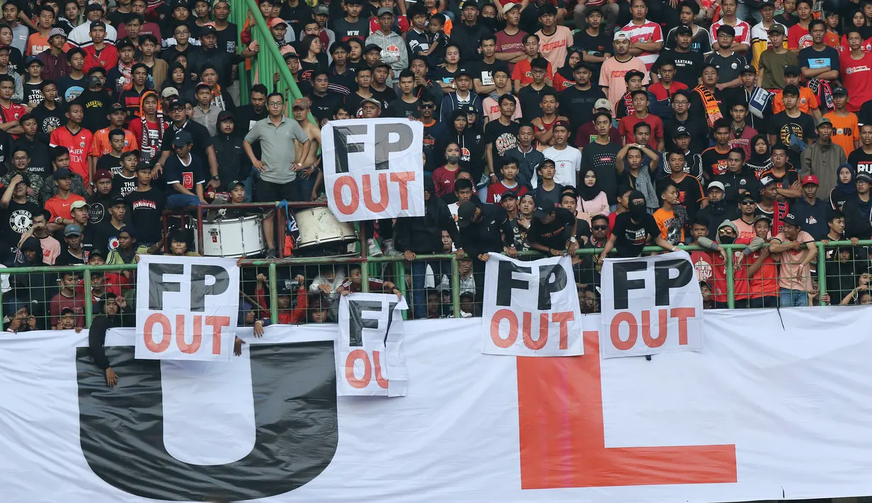Suporter Persija Jakarta memasang spanduk protes saat pertandingan melawan Perseru Badak Lampung pada laga Liga 1 2019 di Stadion Patriot, Bekasi, Minggu (1/9). Persija takluk 0-1 dari Badak Lampung. (Bola.com/M Iqbal Ichsan)