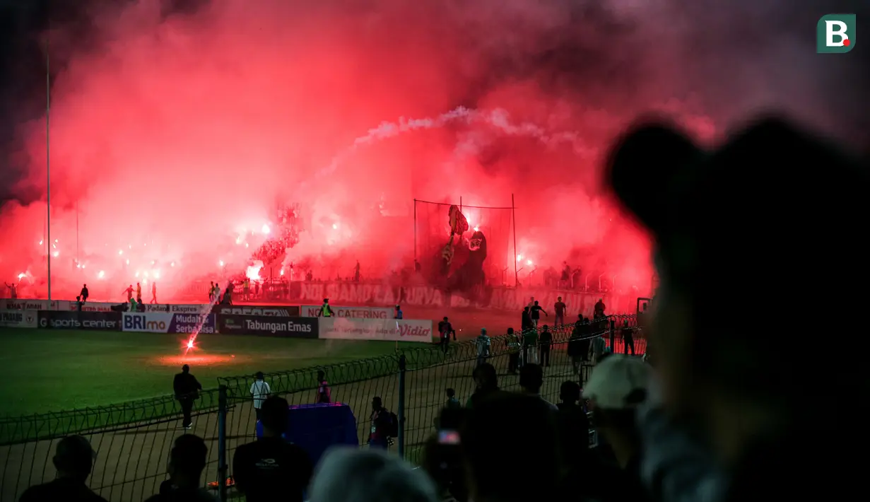 <p>Para suporter menyalakan flare yang membuat laga leg kedua final Pegadaian Liga 2 2023/2024 dihentikan untuk keunggulan PSBS Biak 3-0 atas Semen Padang di Stadion GOR Haji Agus Salim, Padang, Sabtu (9/3/2024). (Bola.com/Bagaskara Lazuardi)</p>