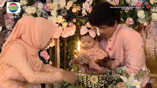 Atta Halilintar dan Aurel Hermansyah mendampingi putri mereka Ameena Hanna Nur Atta menjalani upacara Tedak Siten di acara 7 bulanan. (Foto: Indosiar/Vidio)