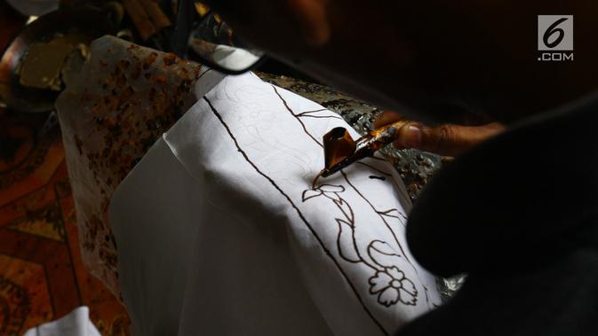 Perajin membuat pola batik bunga anggrek khas Tangerang Selatan pada kain di tempat pembuatan batik kawasan Pamulang, Minggu (21/10). Batik Tangsel ini sudah menembus pasar dunia seperti Makao, Kamboja, China, Hanoi dan Bangkok. (Merdeka.com/Arie Basuki)