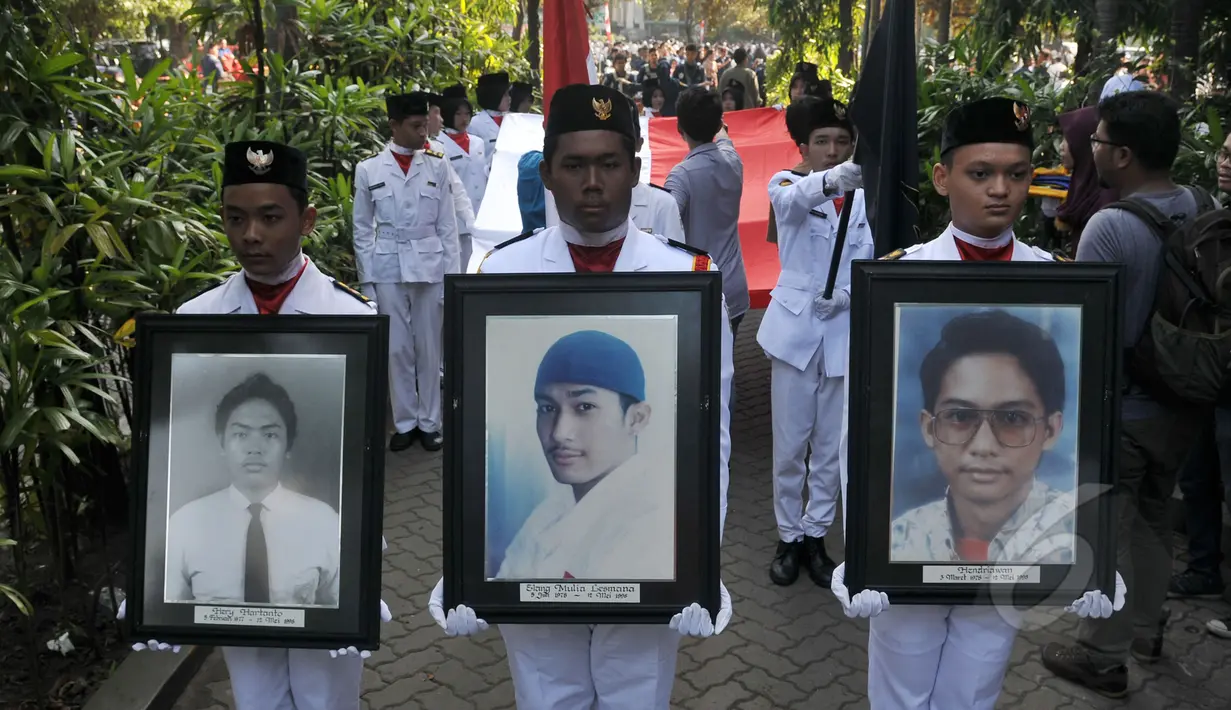 Mahasiswa dengan foto korban tragedi Mei mengikuti Peringatan 17 Tahun Tragedi 12 Mei 1998 di Universitas Trisakti, Jakarta, Selasa (12/5). Kegiatan tersebut untuk mengenang kembali empat mahasiswa Trisakti yang tewas tertembak. (Liputan6.com/Johan Tallo)