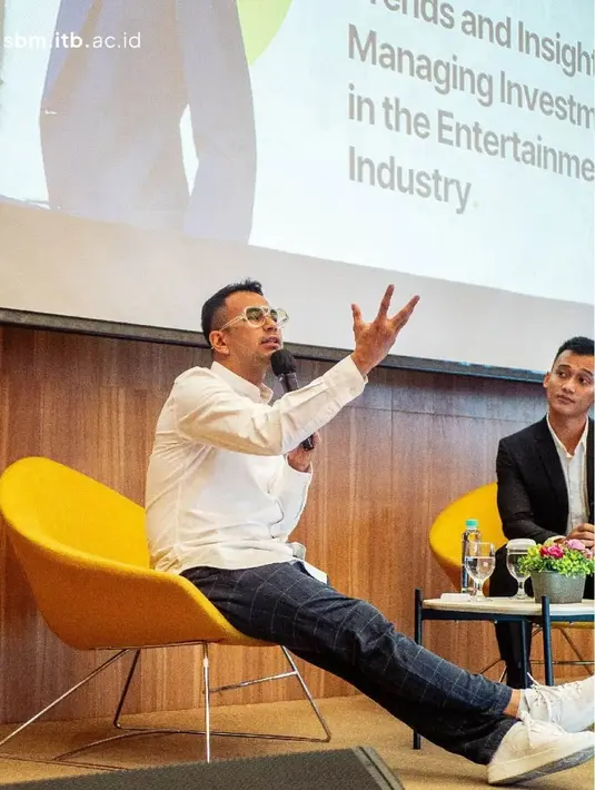 Raffi Ahmad tampil di panggung dengan gaya kasual rapinya. Ia mengenakan kemeja lengan panjang berwarna putih polos, dipadukan mengenakan celana panjang hitam bercorak garis kotak-kotak. [Foto: Instagram/raffinagita1717]