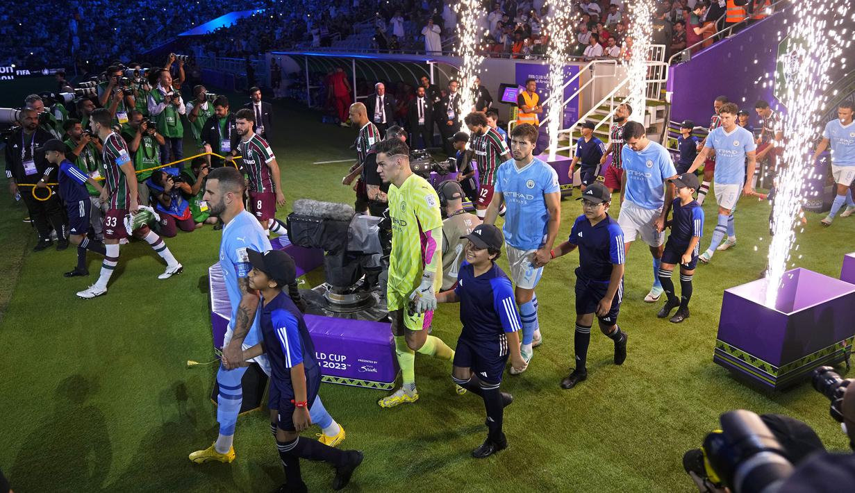 Sejumlah pemain Manchester City dan Fluminense berjalan memasuki lapangan saat laga final Piala Dunia Antarklub 2023 di King Abdullah Sports City, Jeddah, Arab Saudi, Sabtu (23/12/2023) dini hari WIB. (AP Photo/Manu Fernandez)