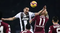 Bek Juventus, Giorgio Chiellini, duel udara dengan striker Torino, Simone Zaza, pada laga Serie A di Stadion Olympic, Turin, Sabtu (15/12). Torino kalah o-1 dari Juventus. (AFP/Marco Bertorello)