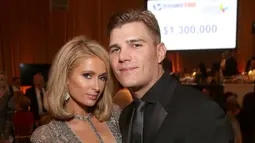 Paris Hilton bersama tunangannya Chris Zylka berpose saat menghadiri Byron Crest's Oscar Gala Viewing Party untuk mendukung Rumah Sakit Anak Los Angeles di Beverly Hills, California (4/3).  (Jesse Grant/Getty Images/AFP)