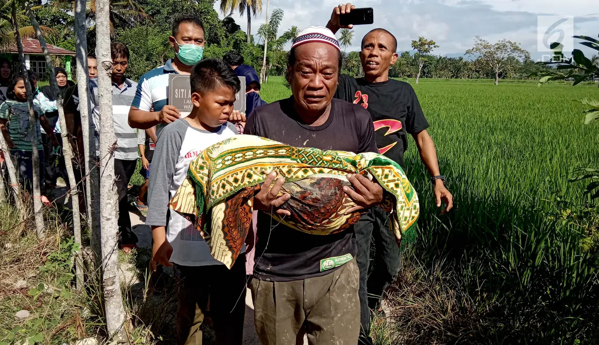 Warga memindahkan jasad dari kuburan di Desa Toto Selatan, Kabupaten Bone Bolango, Gorontalo, Sabtu (12/1). Kepala Desa Toto Selatan Taufik Baladraf membenarkan adanya pemindahan dua kuburan. (Liputan6.com/Arfandi Ibrahim)