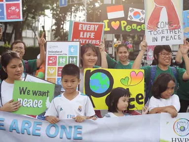 Sejumlah warga melakukan kampanye tentang perdamaian dunia saat car free day di kawasan Bunderan HI, Jakarta, Minggu (27/5). Kampanye tersebut bertujuan sebagai seruan untuk menghentikan peperangan. (Liputan6.com/Faizal Fanani)
