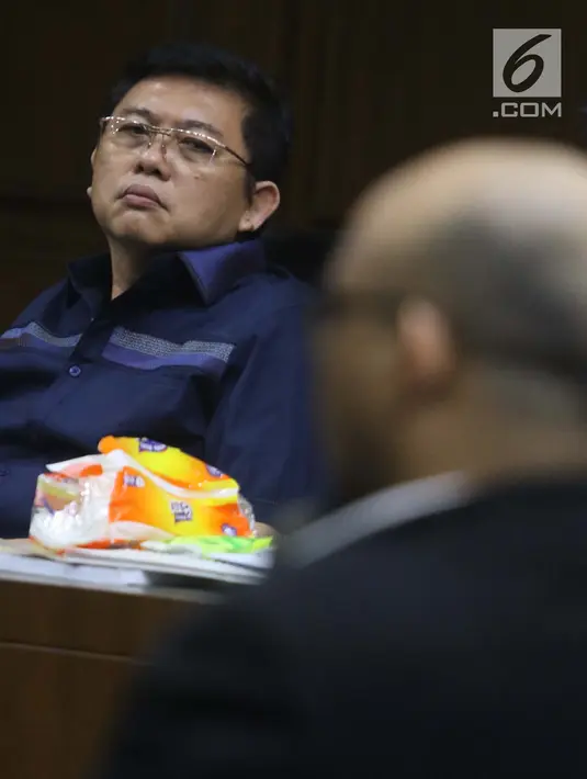 Terdakwa dugaan menghalangi proses penyidikan KPK terhadap Eddy Sindoro, Lucas (kiri) menyimak keterangan Novel Baswedan saat sidang lanjutan di Pengadilan Tipikor Jakarta, Kamis (10/1). Sidang mendengar keterangan saksi. (Liputan6.com/Helmi Fithriansyah)