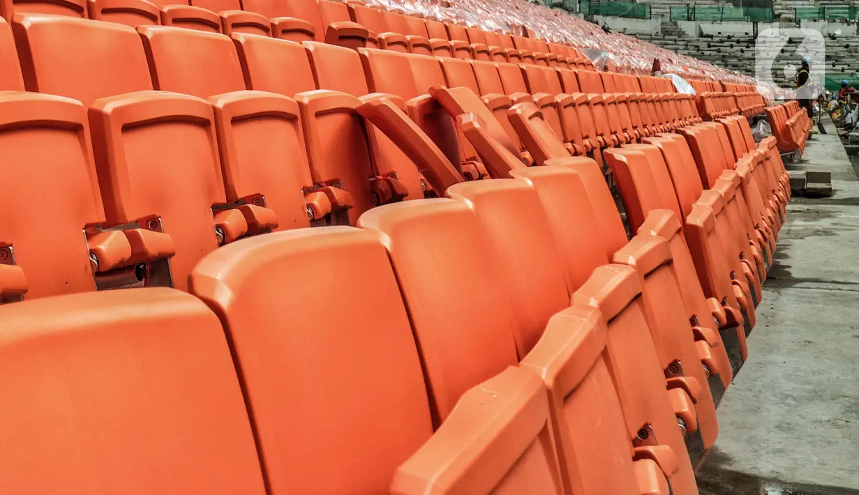 Pekerja saat menyelesaikan pemasangan bangku penonton di lapangan utama Jakarta International Stadium (JIS), Papanggo, Jakarta Utara, Selasa (7/12/2021). Rencananya JIS akan menggunakan atap buka tutup otomatis (retractable roof) serta lampu berstandar FIFA. (merdeka.com/Iqbal S Nugroho)