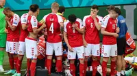 Pemain Denmark mengelilingi tim medis yang tengah merawat Christian Eriksen pada laga melawan Finlandia di Euro 2020, Sabtu (12/6/2021). (AFP/Wolfgang Rattay)