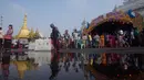 Petugas keamanan setempat berjaga dilokasi festival air tradisional di Yangon, Myanmar (13/4). Selama festival yang penuh warna ini, warga dan wisatawan saling siram air dengan ember dan alat lainnya. (AP Photo/Thein Zaw)