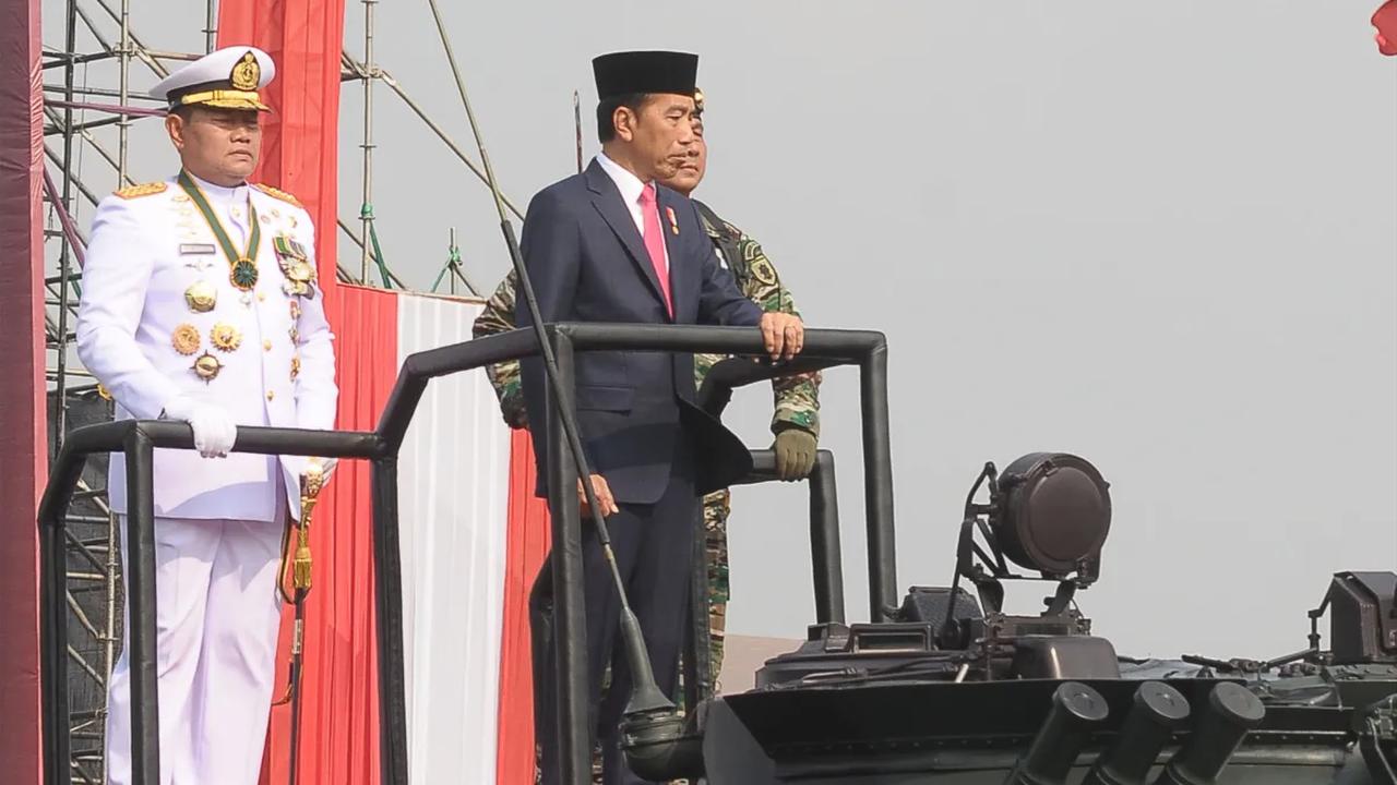 Berdasarkan pantauan di Monas, Jokowi mengenakan peci dan jas hitam. Mantan Gubernur DKI Jakarta itu berdiri tank BMP-3F Korps Marinir.<br>
