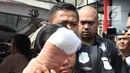 Istri tersangka pembunuhan wartawan Abdullah Fitri Setiawan alias Dufi yang tewas dalam drum, Sari menutupi wajahnya saat digelandang petugas di Polda Metro Jaya, Jakarta, Rabu (21/11). (Merdeka.com/Imam Buhori)