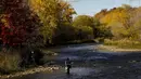Seorang nelayan melemparkan pancingnya saat dia memancing ikan trout di Credit River di antara warna-warni musim gugur di Mississauga, Ontario, pada Kamis, 27 Oktober 2022. (Nathan Denette/The Canadian Press via AP)