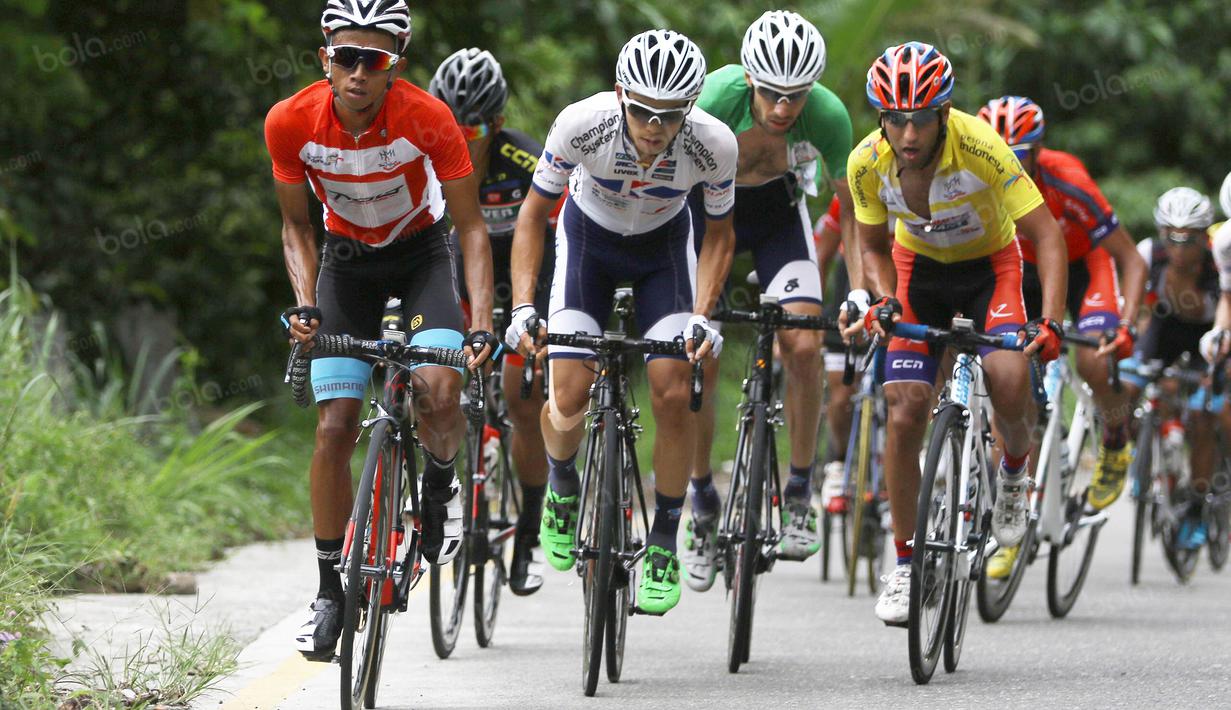 Pebalap Terengganu Cycling Team asal Indonesia, Dady Suryadi (kiri), bersaing ketat dengan para pebalap Iran pada Etape 6 dari Padang Pariaman menuju Sawahlunto, Sumatera Barat, Kamis (11/8/2016).  (Bola.com/Nicklas Hanoatubun)