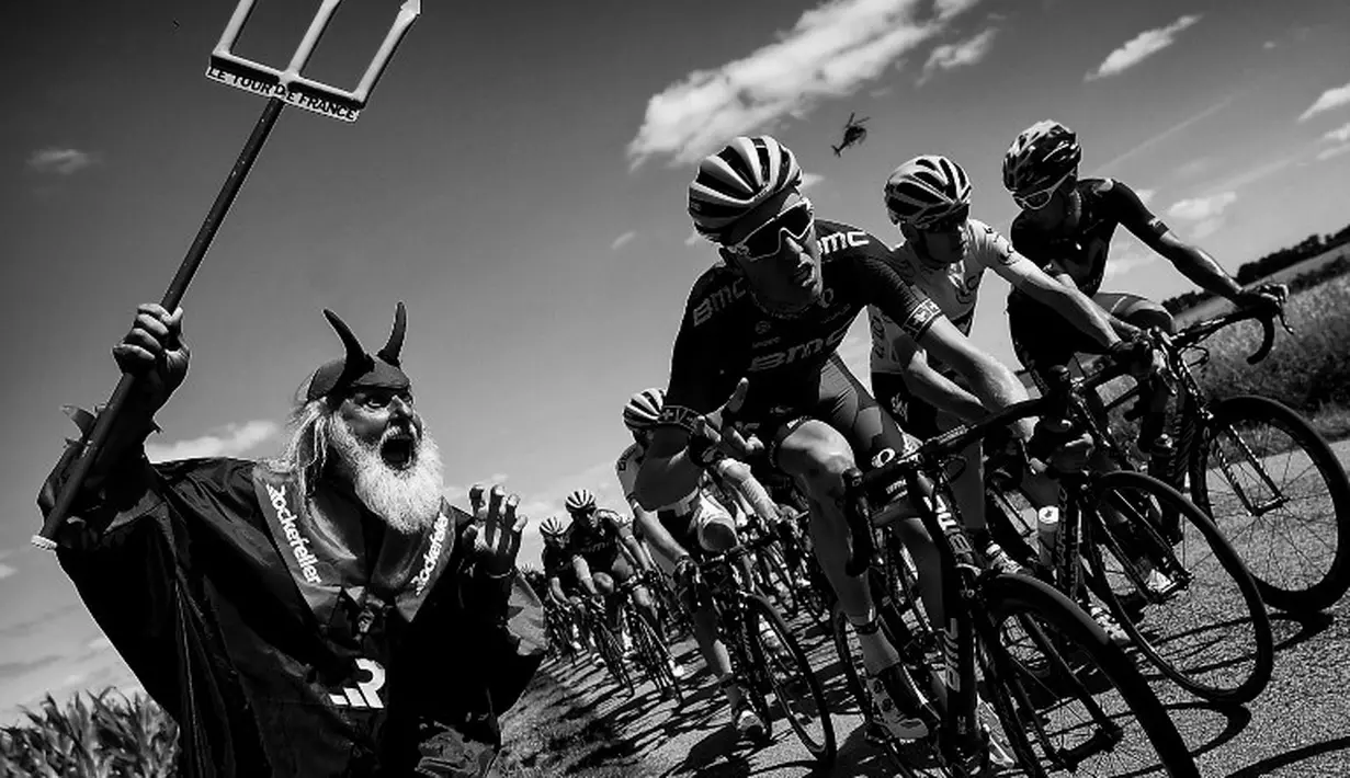 Didi Senft atau yang dikenal dengan El Diablo (kiri) menggoda Christopher Froome saat berlomba di Etape 8 Tour de France antara Rennes dan Mur-de-Bretagne, Prancis. (11/7/2015). (AFP Photo/Lionel Bonaventure) 