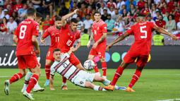 Pemain Portugal Diogo Jota (tengah) berebut bola dengan pemain Swiss Granit Xhaka (tengah belakang) pada pertandingan sepak bola Grup A2 UEFA Nations League di Stadion Stade de Geneve, Jenewa, Swiss, 12 Juni 2022. Portugal kalah tipis 0-1 dari Swiss. (Jean-Christophe Bott/Keystone via AP)
