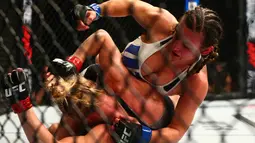 Petarung bebas, Miesha Tate menjatuhkan lawannya Holly Holm  pada ajang UFC 196 di MGM Grand Garden Arena, Las Vegas, Amerika Serikat, Minggu (6/3/2016)  (Reuters/Mark J. Rebilas-USA TODAY Sports)