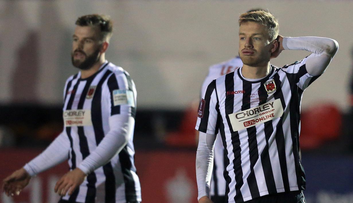 Dua pemain Chorley, bek Andy Halls (kiri) dan gelandang Elliot Newby tampak kecewa usai dikalahkan Wolverhampton Wanderers 0-1 dalam laga babak keempat Piala FA 2020/21 di Victory Park Stadium, Jumat (22/1/2021). (AFP/Lindsey Parnaby)