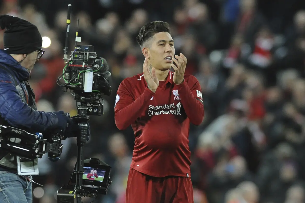 Striker Liverpool, Roberto Firmino, menyapa suporter usai mengalahkan Arsenal pada laga Premier League di Stadion Anfield, Liverpool, Sabtu (29/12). Liverpool menang 5-1 atas Arsenal. (AP/Rui Veira)