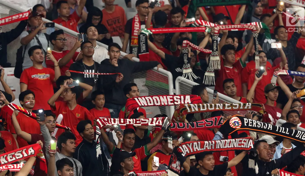 Suporter membentangkan syal saat menyaksikan laga Timnas Indonesia U-19 melawan Chinnese Taipei pada penyisihan Grup A Piala AFC U-19 2018 di Stadion GBK, Jakarta, Kamis (18/10). Indonesia unggul 3-1. (Liputan6.com/Helmi Fithriansyah)