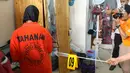 Tersangka pembunuhan wanita yang ditemukan tewas di dalam lemari saat memeragakan adegan peristiwa di TKP di kawasan Mampang, Jakarta, Jumat (23/11). 13 adegan dilakukan para tersangka. (Liputan6.com/Helmi Fithriansyah)