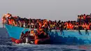 Petugas penyelamat mendekati kapal kayu yang disesaki sejumlah imigran, di lepas panti Libya, Laut Mediterania, Senin (29/8).  Para penjaga pantai Italia berhasil menyelamatkan sekitar 6.500 imigran dari Eritrea dan Somalia. (REUTERS/Giorgos Moutafis)