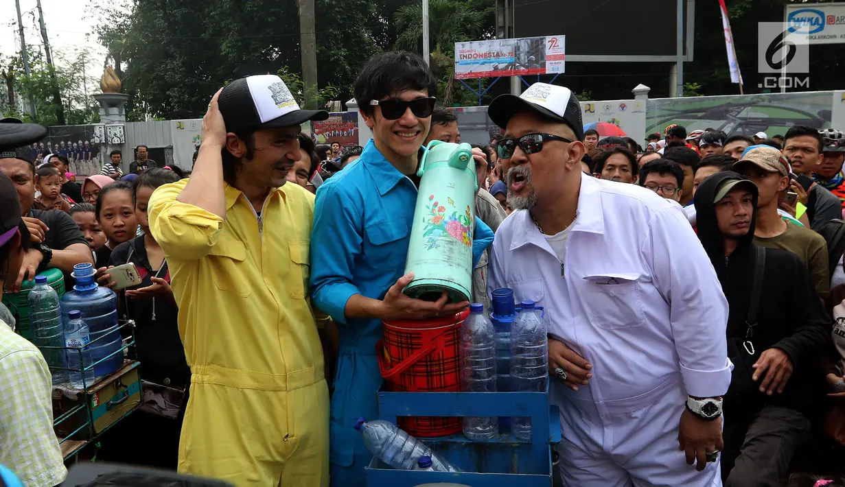 Aktor Abimana, Vino G. Bastian dan Indro foto di sepeda kopi bersama pengunjung Car Free Day saat promo film Warkop DKI Reborn part 2 di Senayan, Jakarta, Minggu (13/08). (Liputan6.com/Fery Pradolo)