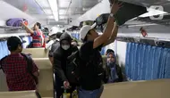 Penumpang menaikkan barang bawaan di dalam gerbong Kereta Api Jarak Jauh (KAJJ) di Stasiun Pasar Senen, Jakarta, Rabu (26/3/2025). (Liputan6.com/Herman Zakharia)