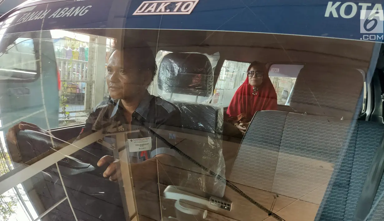 Pengemudi angkot Jak Lingko yang dilengkapi pendingin (AC) membawa penumpang di depan Stasiun Tanah Abang, Jakarta, Jumat (12/7/2019). Sebanyak lima armada Jak Lingko ber-AC mulai diuji coba sejak 1 Juli  untuk mengangkut penumpang dari Tanah Abang ke Kota. (Liputan6.com/Immanuel Antonius)