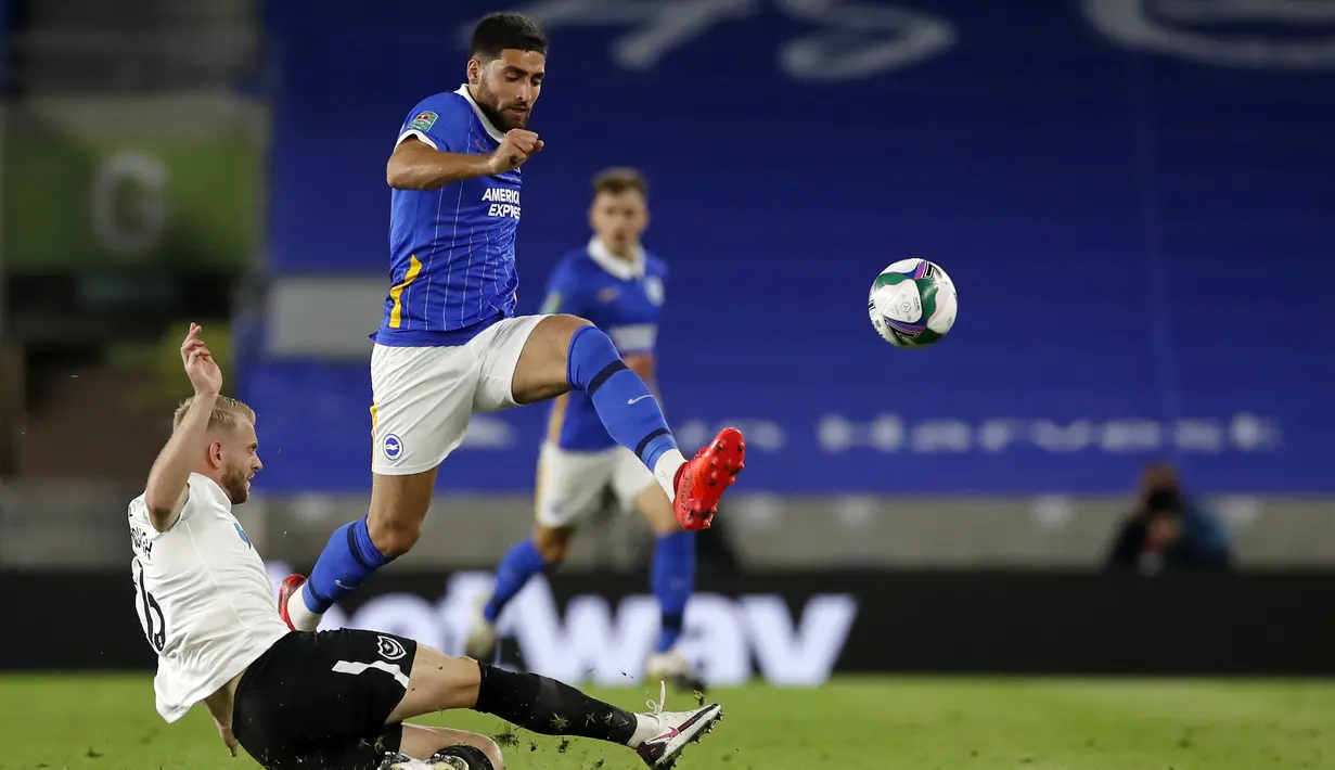 Gelandang Brighton, Alireza Jahanbakhsh, berebut bola dengan bek Portsmouth, Jack Whatmough, pada laga Piala Inggris di Falmer Stadium, Jumat (18/9/2020) dini hari WIB. Brighton menang 4-0 atas Portsmouth. (AFP/Paul Childs/pool)
