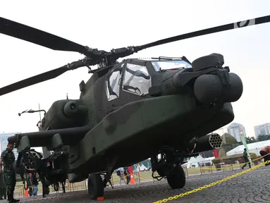 Anggota TNI berada di sisi helikopter Apache yang dipamerkan pada pameran Alat Utama Sistem Persenjataan TNI di Kawasan Monas, Jakarta, Kamis (27/9). TNI memiliki delapan helikopter Apache AH 64E buatan Amerika Serikat. (Liputan6.com/Helmi Fithriansyah)