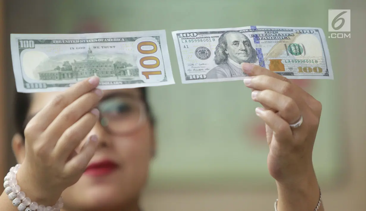Teller menunjukkan mata uang dolar di Jakarta, Jumat (2/2). Deputi Gubernur Senior BI Mirza Adityaswara mengatakan, posisi nilai tukar rupiah terhadap dolar Amerika Serikat yang berada di level Rp13.700 hingga Rp13.800.(Liputan6.com/Angga Yuniar)