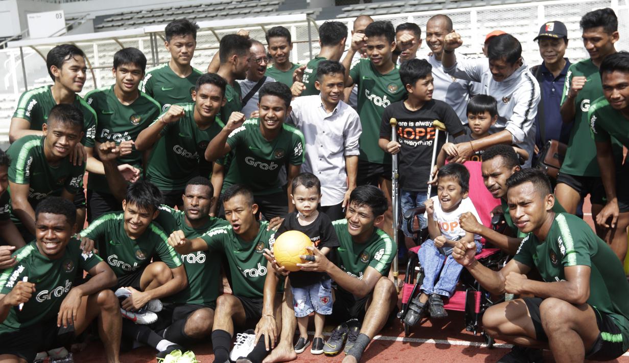 Pelatih dan pemain Timnas Indonesia U-23 foto bersama anak-anak yang datang ke Stadion Madya, Jakarta, Rabu (13/3). Sejumlah anak dari Yayasan Rumah Harapan Indonesia datang menemui Timnas U-23 (Bola.com/Vitalis Yogi Trisna)