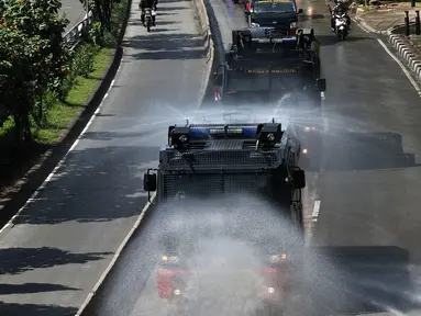 Mobil Water Cannon milik Polisi menyemprotkan Disinfektan di jalan Slipi, Jakarta, Selasa (31/3/2020). Meluasnya Covid-19 membuat petugas kepolisian Berinisiatif menyemprotkan Disinfektan menggunakan Water Cannon memutari jalan, Petamburan, Slipi Raya Jakarta Barat. (Liputan6.com/Johan Tallo)
