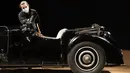 Staf berpose dengan Bugatti Type 57S 1937, salah satu mobil pra-perang paling diinginkan di dunia, di luar rumah lelang Bonhams,  London, Selasa (16/2/2021). Bugatti yang tidak pernah terlihat selama 50 tahun ini merupakan salah satu dari 42 contoh varian 57S yang diproduksi (DANIEL LEAL-OLIVAS/AFP)