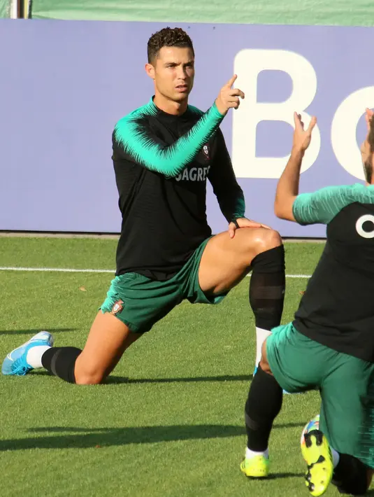 Penyerang Portugal, Cristiano Ronaldo (tengah) melakukan pemanasan dalam sesi latihan di Vilnius, Lithuania (9/9/2019). Portugal akan bertanding melawan Lithuania pada grup B Kualifikasi Euro 2020. (AFP Photo/Petras Malukas)