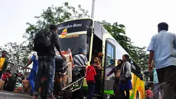 Para pemudik bersiap menaiki bus yang akan memberangkatkan mereka ke kampung halaman (Liputan6.com/Faizal Fanani)