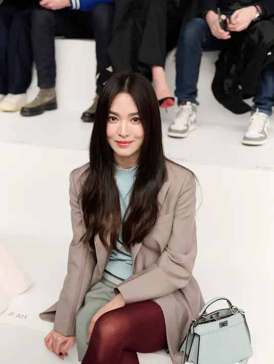 Song Hye Kyo tampil edgy dengan parisian look multiwarna. Ia memadukan atasan sky blue dengan skirt pants abu-abu dan stocking merah. Dilegkapi dengan handbag Fendi biru muda dan blazer cokelat. [Fendi]