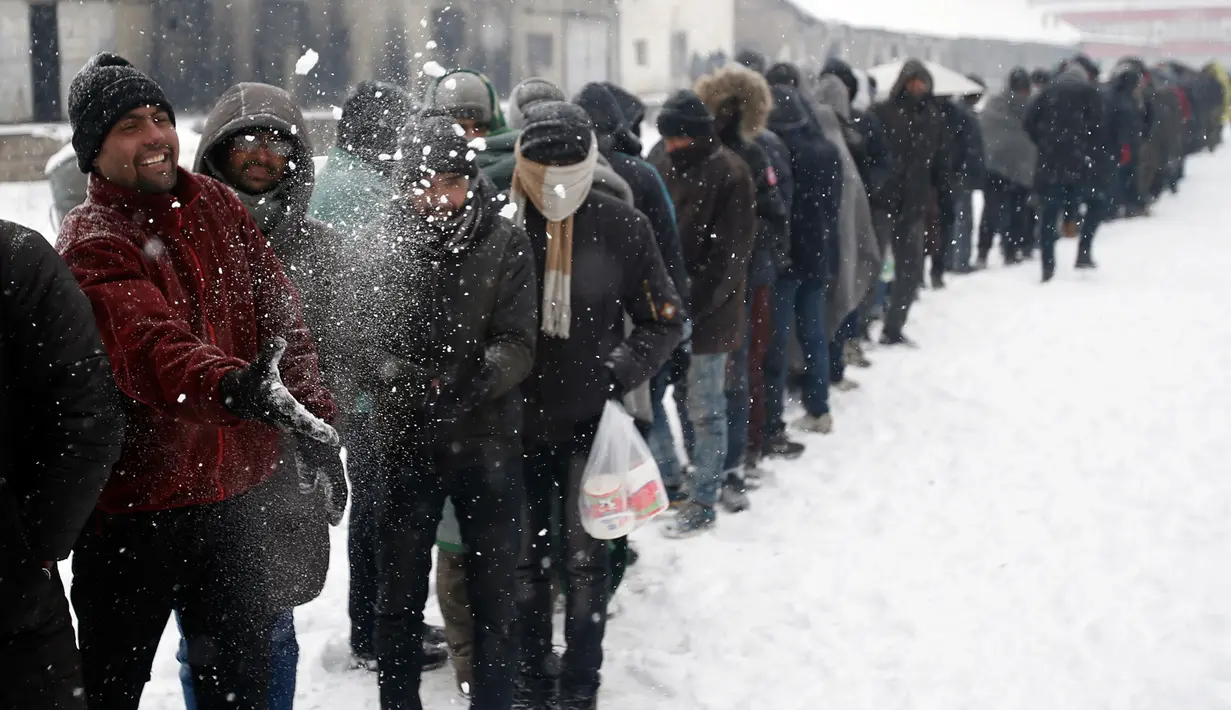 Sejumlah imigran mengantre untuk mendapat makanan hangat di kamp pengungsian di Belgrade, Serbia (11/1). Imigran harus berjuang melawan dengan cuaca dingin yang cukup ekstrem. (AP Photo/Darko Vojinovic)