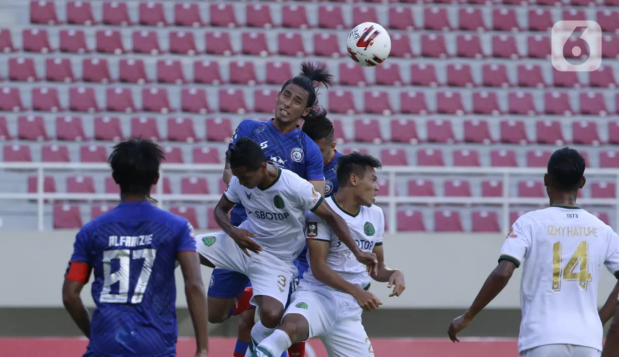 Bek Persikabo 1973 Andy Setyo Nugroho duel udara dengan pemain Arema FC Hanif Sjahbandi pada laga Piala Menpora di Stadion Manahan, Solo, Minggu (21/3/2021). Kedua tim bermain imbang 1-1. (Bola.com/M Iqbal Ichsan)