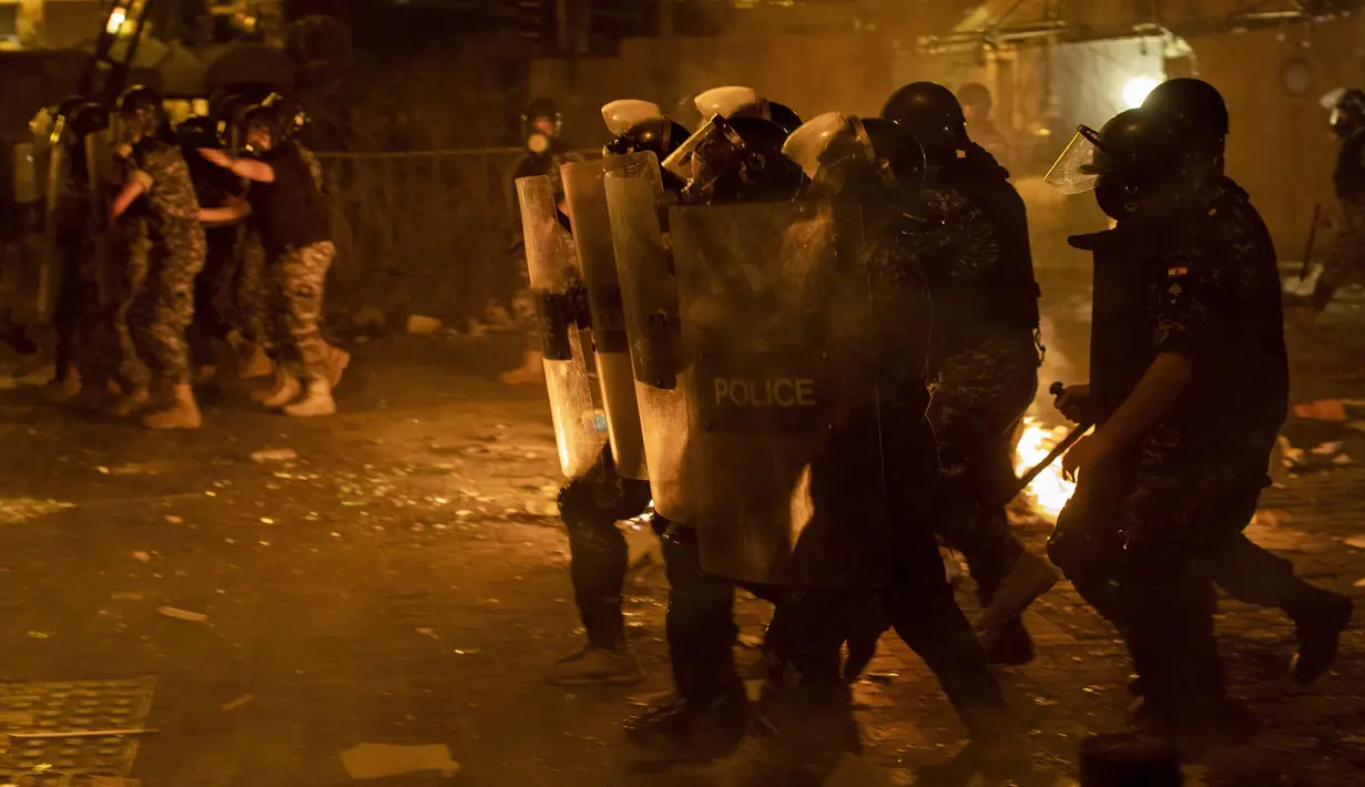 Polisi antihuru-hara bergerak maju untuk mendorong kembali pengunjuk rasa antipemerintah selama protes terhadap elite politik yang telah memerintah negara selama beberapa dekade di Beirut, Lebanon, Jumat (7/8/2020). (AP Photo/Hassan Ammar)