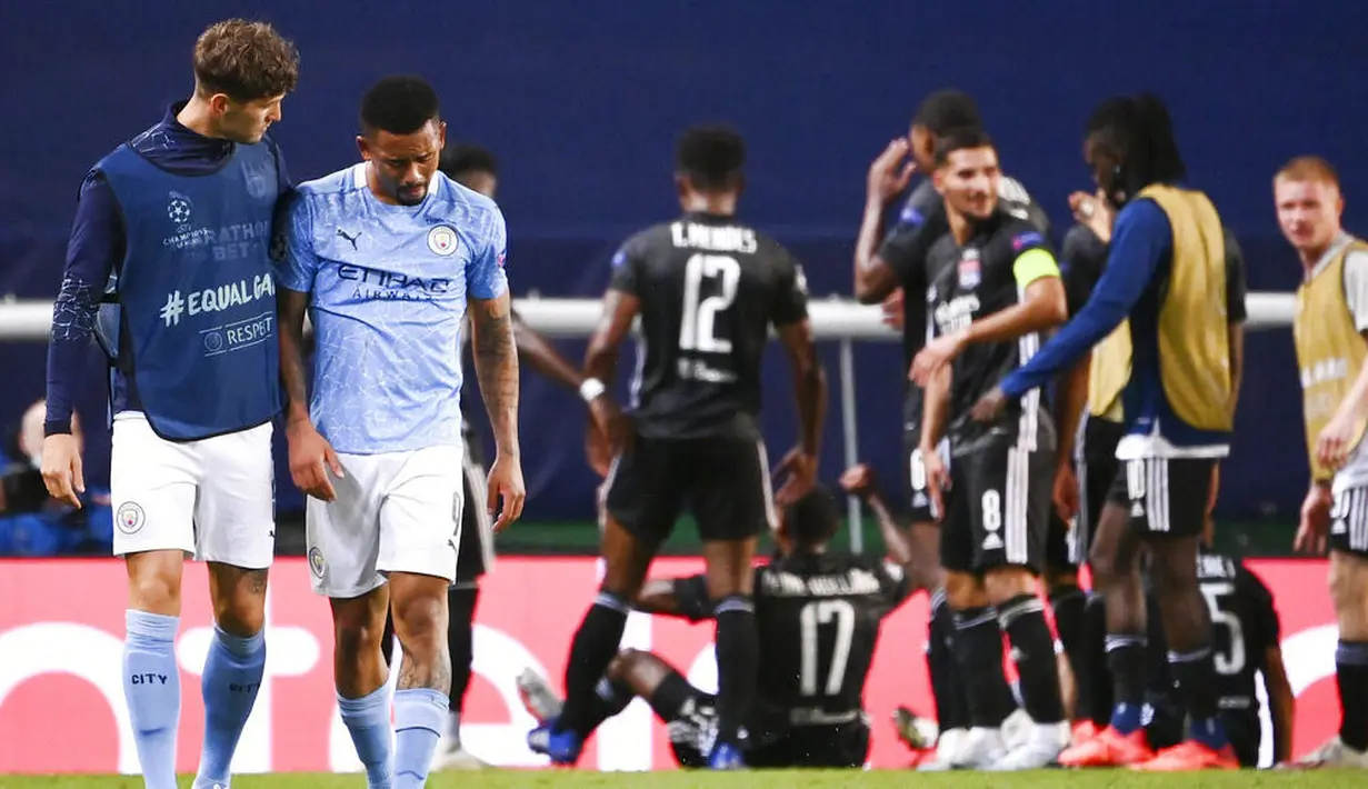 Pemain Manchester City, John Stones, berusaha menguatkan Gabriel Jesus usai ditaklukkan Lyon pada perempat final Liga Champions di Stadion Jose Alvalade, Sabtu (15/8/2020). Lyon menang 3-1 atas Manchester City.  (Franck Fife/Pool Photo via AP)