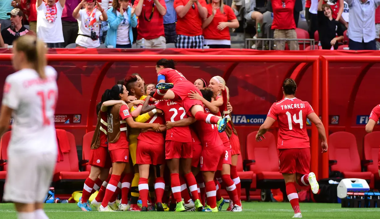 Para pemain Kanada menghampiri Josee Belanger usai mencetak gol ke gawang Swiss di Piala Dunia wanita 2015 di BC Place Stadium, Senin (22/6/2015). Kanada melaju ke perempat final menunggu pemenang antara Norwegia vs Inggris. (Reuters/Anne Marie Sorvin)