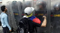 Demonstran bentrok dengan petugas saat unjuk rasa anti-Presiden Nicolas Maduro di San Cristobal, Venezuela (26/10). Aksi unjuk rasa ini tak hanya berlangsung di Caracas, tetapi juga digelar serentak di lokasi lainnya. (REUTERS/Carlos Eduardo Ramirez)